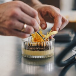 a close up of a person decorating a dessert